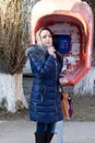 Pretty woman shopper at a public phone booth Royalty Free Stock Photo