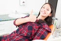 Pretty woman showing thumb up in dentist chair Royalty Free Stock Photo