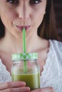 Pretty woman sipping on green juice Royalty Free Stock Photo