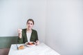 Pretty woman sitting at a restaurant at the table and looking at food in astonishment