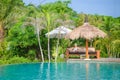 A Pretty woman sitting in the tropical shade a pool