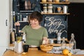 Pretty woman with a smile in her teeth prepares a delicious juice from fresh oranges Royalty Free Stock Photo