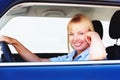 Pretty woman smiling from the drivers seat of a car. Smiling blond woman in a car sitting at the drivers seat. Royalty Free Stock Photo