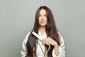 Pretty woman straighten her hair on white background. Haircare concept Royalty Free Stock Photo