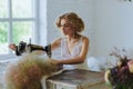 Pretty Woman. In the style of Coco Chanel sitting on a sewing machine Royalty Free Stock Photo