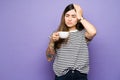 Pretty woman suffering from a headache and drinking coffee Royalty Free Stock Photo