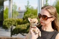 Pretty woman in sunglasses with small chihuahua in hands Royalty Free Stock Photo