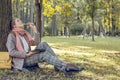 Pretty woman with tablet laptop sitting on green grass, working and relaxing in park outdoors Royalty Free Stock Photo