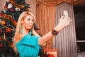 Pretty woman taking selfie photo on mobile phone Christmas tree