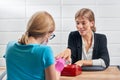 Pretty woman talking with manicurist while she doing manicure in beauty salon.