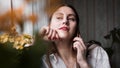 Pretty woman talking on phone near window at home in morning sunlight Royalty Free Stock Photo