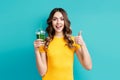 Pretty woman with tasty green detox juice on blue background