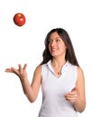 Pretty woman tosses apple in air isolated Royalty Free Stock Photo