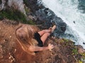 Pretty woman tourist sitting on the cliff