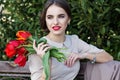 Pretty woman with tulips sitting on the bench Royalty Free Stock Photo