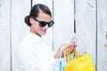 Pretty woman using her smartphone holding shopping bags Royalty Free Stock Photo