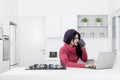 Pretty woman using a laptop in the kitchen Royalty Free Stock Photo