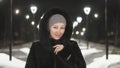 Pretty woman walking along the black fur coat. Outdoor. Girl walks on a winter night among the street lights of the city Royalty Free Stock Photo