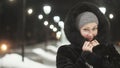 Pretty woman walking along the black fur coat. Outdoor. Girl walks on a winter night among the street lights of the city Royalty Free Stock Photo