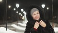 Pretty woman walking along the black fur coat. Outdoor. Girl walks on a winter night among the street lights of the city Royalty Free Stock Photo