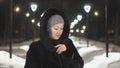 Pretty woman walking along the black fur coat. Outdoor. Girl walks on a winter night among the street lights of the city Royalty Free Stock Photo