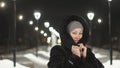 Pretty woman walking along the black fur coat. Outdoor. Girl walks on a winter night among the street lights of the city Royalty Free Stock Photo