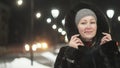 Pretty woman walking along the black fur coat. Outdoor. Girl walks on a winter night among the street lights of the city Royalty Free Stock Photo