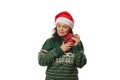 Pretty woman in warm green woolen sweater and Santa hat, with Christmas gift box in her hands, over white background Royalty Free Stock Photo