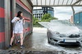 Pretty woman washing  and car cleaning with foam and pressured water Royalty Free Stock Photo