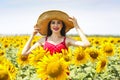 Pretty woman wearing the big hat in sunflower field Royalty Free Stock Photo