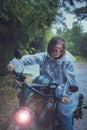 pretty woman wearing plastic rain clothes riding small enduro motorcycle