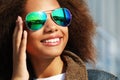 Pretty woman wearing sunglasses with perfect teeth and dark clean skin having rest outdoors Royalty Free Stock Photo