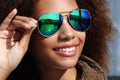 Pretty woman wearing sunglasses with perfect teeth and dark clean skin having rest outdoors Royalty Free Stock Photo