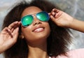 Pretty woman wearing sunglasses with perfect teeth and dark clean skin having rest outdoors Royalty Free Stock Photo