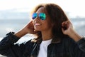 pretty woman wearing sunglasses with perfect teeth and dark clean skin having rest outdoors Royalty Free Stock Photo