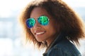 pretty woman wearing sunglasses with perfect teeth and dark clean skin having rest outdoors Royalty Free Stock Photo