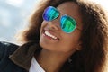 Pretty woman wearing sunglasses with perfect teeth and dark clean skin having rest outdoors Royalty Free Stock Photo