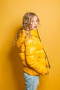 Pretty woman in winter jacket posing on bright yellow background. Positive emotion Royalty Free Stock Photo