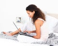 Pretty woman working on her laptop on her bed Royalty Free Stock Photo