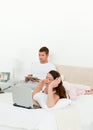 Pretty woman working on her laptop on her bed Royalty Free Stock Photo