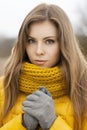 Pretty woman in a yellow knit scarf. winter weather.