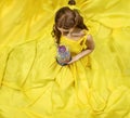 Pretty woman in the yellow long dress closeup with red rose in her hands. Beauty and the beast cosplay art processing. Royalty Free Stock Photo