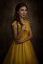 Pretty woman in the yellow long dress closeup with red rose in her hands. Beauty and the beast cosplay Royalty Free Stock Photo