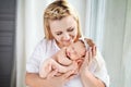Pretty woman holding a newborn baby girl in her arms. Happy mother and her slipping newborn baby.  Happy family concept Royalty Free Stock Photo