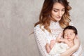 Pretty woman holding a newborn baby in her arms. Portrait of mother and little baby. Copy space Royalty Free Stock Photo