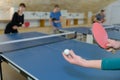 Pretty woman playing ping-pong with friends Royalty Free Stock Photo