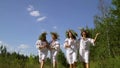 Pretty women in slavic traditional dresses and circlets walking barefoot outside