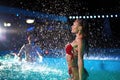 Pretty woman in wet bikini dancing and hanging out with friends at night pool party. People having fun splashing water Royalty Free Stock Photo