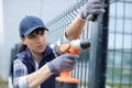 pretty worker installing welded metal mesh fence Royalty Free Stock Photo