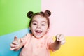 Pretty 4-year little girl with funny face on multicolor background. Bright colors and stylish picture